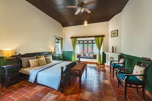 a bedroom with a bed and a ceiling fan at SaffronStays Calamondinn Bungalow, Coorg in Gonikoppal