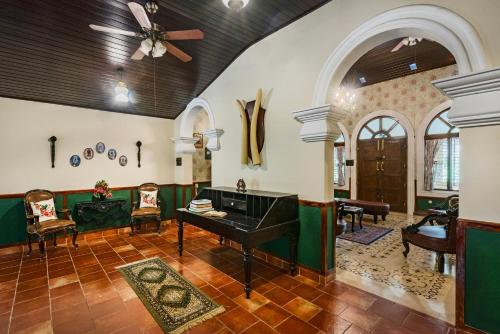a living room with a piano and chairs at SaffronStays Calamondinn Bungalow, Coorg in Gonikoppal