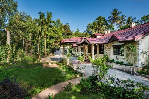 an aerial view of a house with a yard at SaffronStays Calamondinn Bungalow, Coorg in Gonikoppal