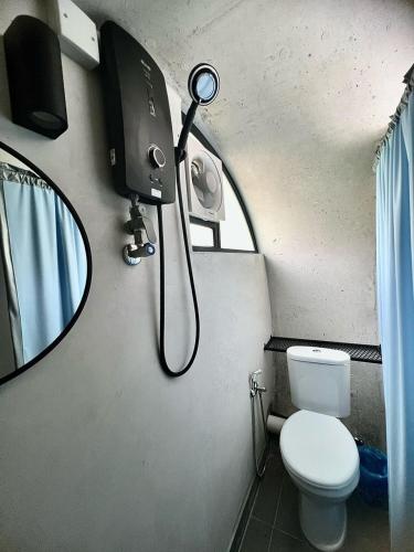 a shower in a bathroom with a toilet and a mirror at The Cozytainer in Taiping