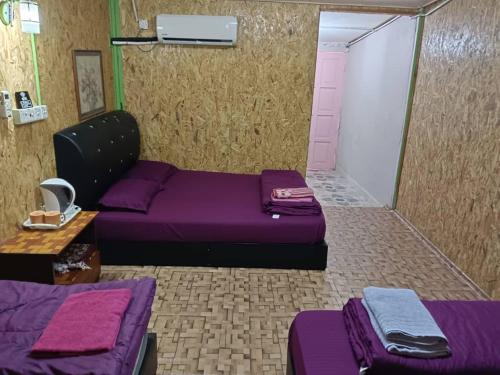 a room with two beds and a purple couch at Perhentian Alia guest house in Perhentian Island