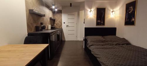 a small room with a bed and a kitchen at Apartamenty Obidowa in Obidowa