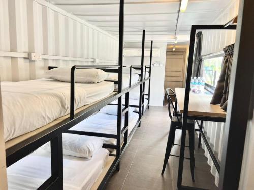 a room with four bunk beds and a desk at The Cozytainer in Taiping