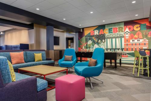 a waiting room with blue chairs and a table at Tru By Hilton Bracebridge, On in Bracebridge