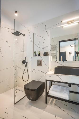 a white bathroom with a black toilet and a sink at Avgi Luxury Villa in Svoronata