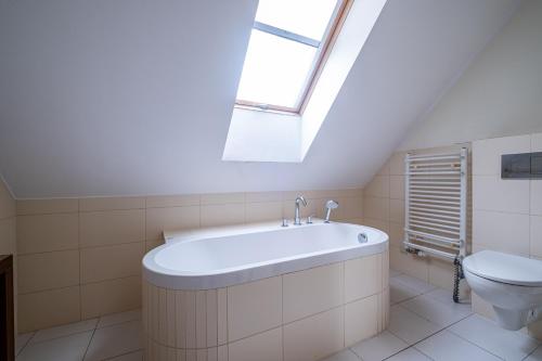 a bathroom with a bath tub and a toilet at Dębki Playa Apartments in Dębki