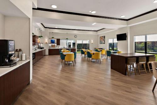 a dining room and living room with yellow chairs at Comfort Suites Columbus East Broad in Columbus