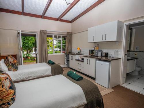 a kitchen with two beds in a room at The Cock House in Grahamstown