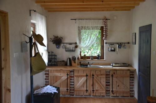 a kitchen with a counter with a sink and a window at Lawendowa Osada in Przywidz