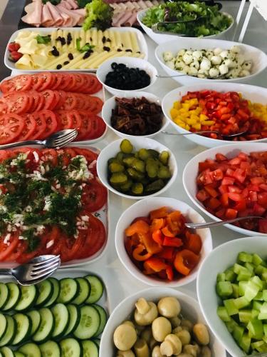 a table filled with bowls of different types of vegetables at Hotel Sulbin in Garwolin