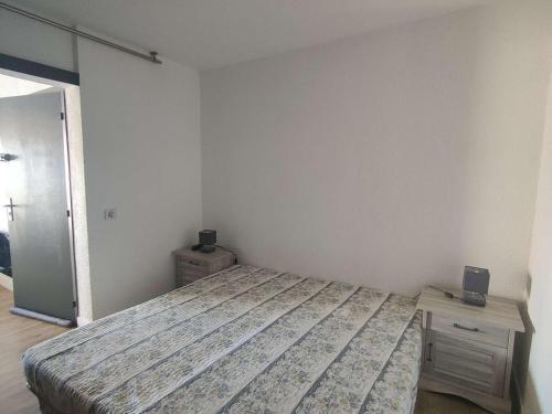 une chambre avec un lit et une table de chevet en bois dans l'établissement Appartement T2 pour 5 pers avec piscine et parking - Le Barcarès - FR-1-195-88, au Barcarès