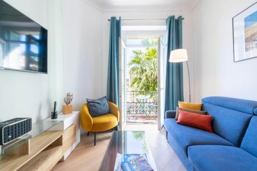 un salon avec un canapé bleu et une table en verre dans l'établissement Modern 2-Br Apartment with Balconies 3 Min from Palais des Festivals, à Cannes