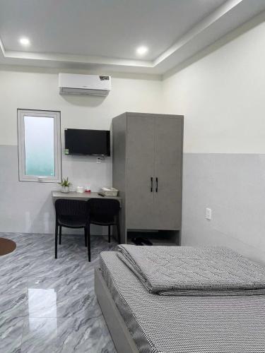 a bedroom with two beds and a table and a cabinet at Hiệp Phát in Buôn Kô Tam