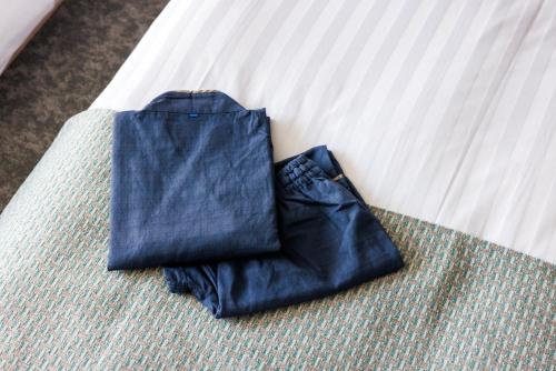 a pair of blue jeans sitting on a bed at &Here TOKYO UENO in Tokyo