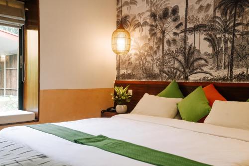 a bedroom with a bed with colorful pillows at Kasara Chitwan in Chitwan