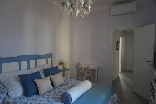 a bedroom with a blue and white bed with blue pillows at Viareggio, Sweet home in Viareggio