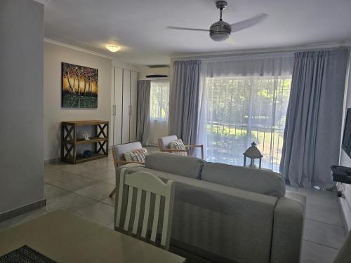 a living room with a couch and a large window at Sea's the Day in St Lucia