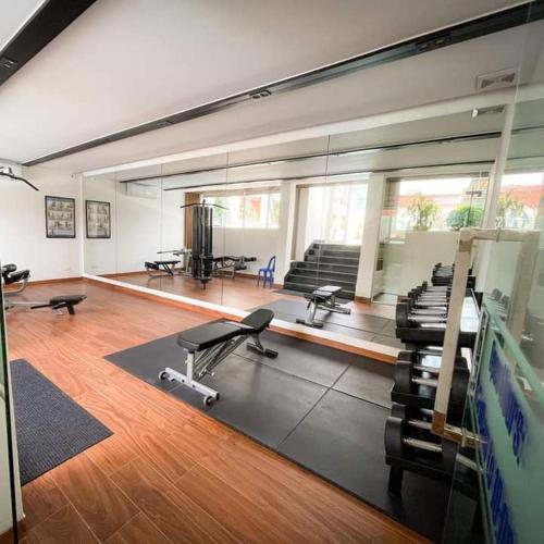 a large room with a gym with desks and chairs at HAMPTONS Apartments in Phnom Penh