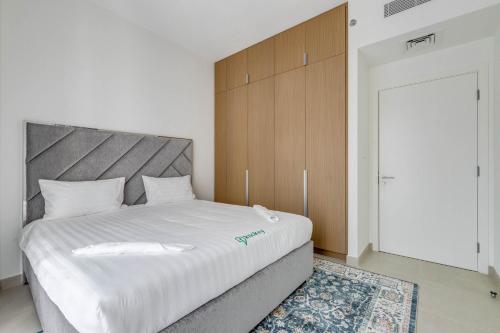 a bedroom with a large white bed with a wooden headboard at Knokey Dubai Creek Beach with Lagoon Pool access in Dubai