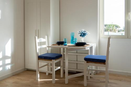 a dining room table with two chairs and a white table at La finestra di sale Casa vacanza al mare in Anzio