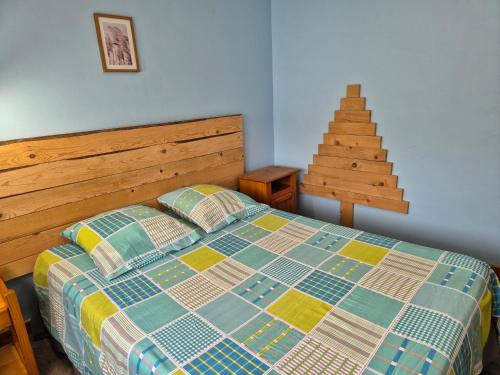 - une chambre avec un lit doté d'une tête de lit en bois et d'un escalier dans l'établissement Gite Perce Neige, à Foncine-le-Haut