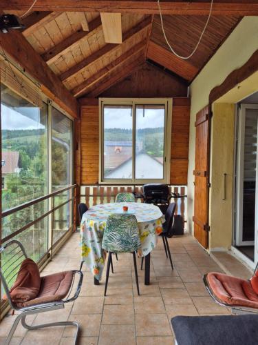une pièce avec une table et des chaises sur un balcon dans l'établissement Gite Perce Neige, à Foncine-le-Haut