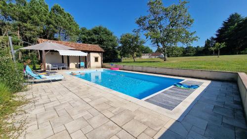 - une piscine avec une terrasse et une maison dans l'établissement Beautiful country house for 10 with swimming pool, à Saint-Méard-de-Gurçon