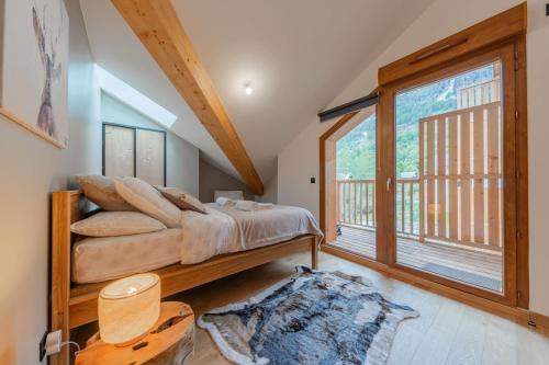 une chambre avec un lit et une grande fenêtre dans l'établissement Appartment T4 Cerf Che pour 8 pers à Monetier Les Bains proche départ des pistes, au Monêtier-les-Bains