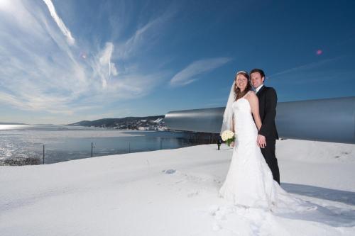 a bride and groom posing for a picture in the snow at Oscarsborg Castle Hotel & Resort in Drøbak
