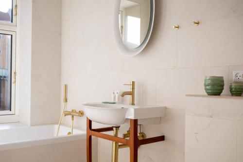 a bathroom with a sink and a mirror and a tub at Lovely Apartment by w Bathtub and Balcony in Copenhagen