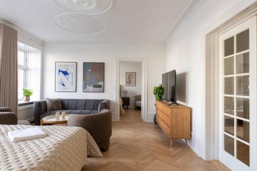 a living room with a bed and a couch and a tv at Lovely Apartment by w Bathtub and Balcony in Copenhagen