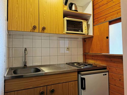 une cuisine avec un évier et un micro-ondes dans l'établissement Rond Point Des Pistes - Studio 4 personnes idéalement situé MAE-8301, à Tignes