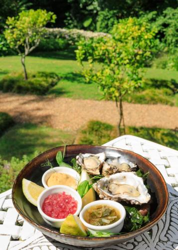 a plate of oysters and other foods on a table at The Cellars-Hohenort in Cape Town
