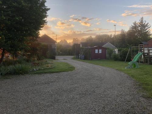 a gravel driveway with a playground and a slide at Le coteau de l'orme in Dosches