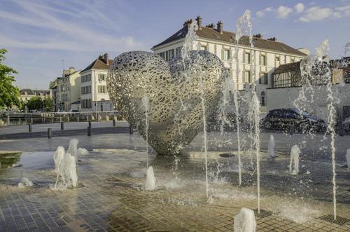 a fountain with a heart in the middle of a city at Le coteau de l'orme in Dosches