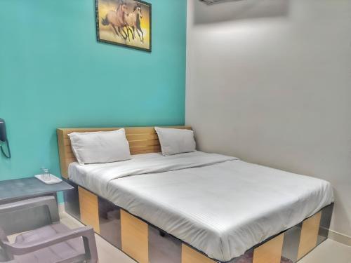 a pair of beds in a room with a table at Hotel Pragati Heights in Mathura