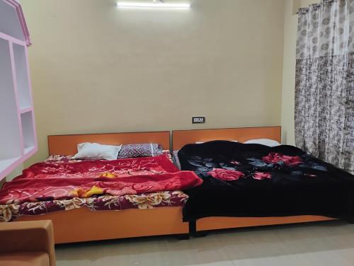 two beds sitting next to each other in a bedroom at Geeta Teerth Guest House AC and Non AC Rooms in Ayodhya