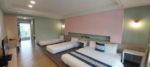 a hotel room with two beds and a couch at Coconutpalm Home in Hengchun