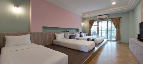 a hotel room with two beds and a couch at Coconutpalm Home in Hengchun