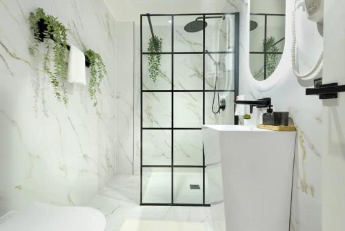 a bathroom with white marble walls and a shower at AIASTAY Bucharest River Apartments in Bucharest