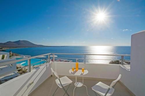 a balcony with a table and chairs and the ocean at Kaladi Rock Avlemonas in Avlemonas