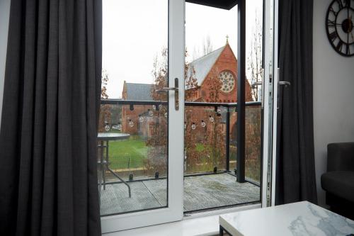 a sliding glass door with a view of a church at Luxury Ensuite Apartment with shared living room and kitchen in Manchester