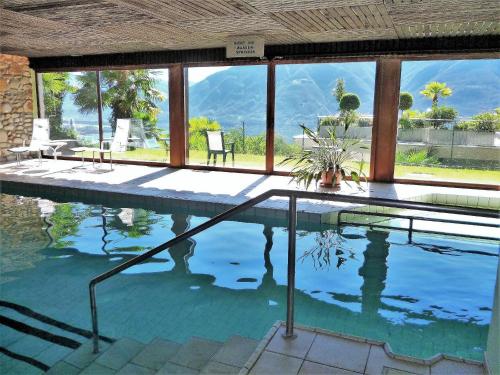 a swimming pool with a view of the mountains at Collina d'Oro C14 by Fewotessin in Orselina