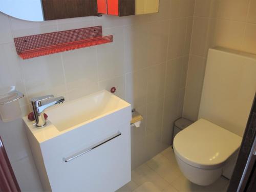 a bathroom with a white sink and a toilet at Casa Gialla by Fewotessin in Verscio