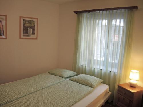 a bedroom with a bed and a window at Casa Gialla by Fewotessin in Verscio