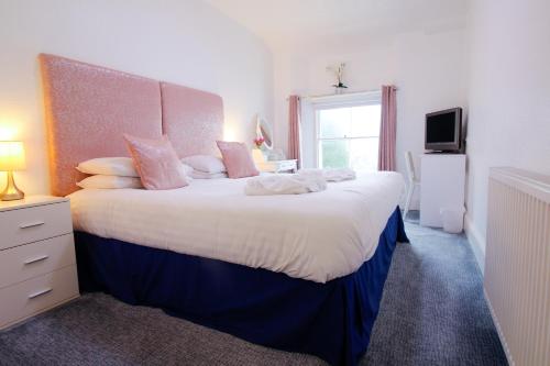 a bedroom with a large bed and a window at Allerdale in Torquay