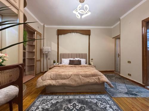 a large bedroom with a large bed and a chandelier at Sunset homes in Downtown Cairo in Cairo