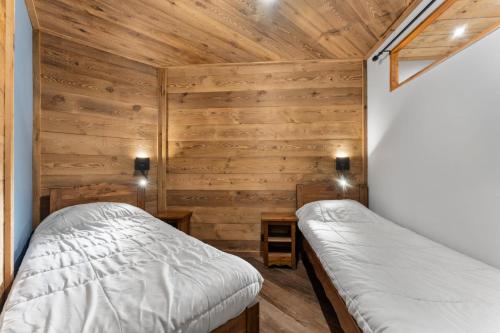 deux lits dans une chambre aux murs en bois dans l'établissement Résidence Les Hauts De Preclaux - Appartement cosy pour 6 personnes aux Orres 1800 MAE-5041, aux Orres