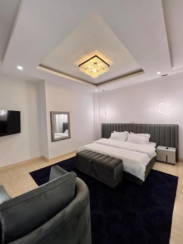a bedroom with a large bed and a couch at Delia Residence 4Bed Duplex in Ikoyi in Lagos