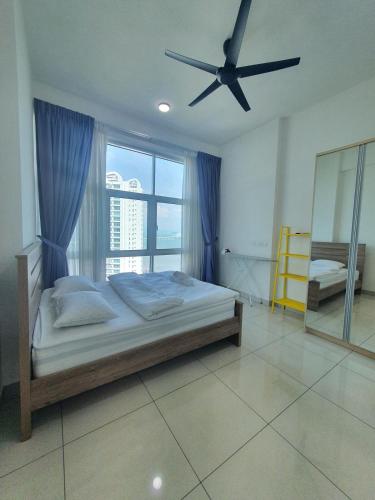 a bedroom with a bed and a ceiling fan at Southbay Seaview Condo A23 #10minQueensbay in Bayan Lepas